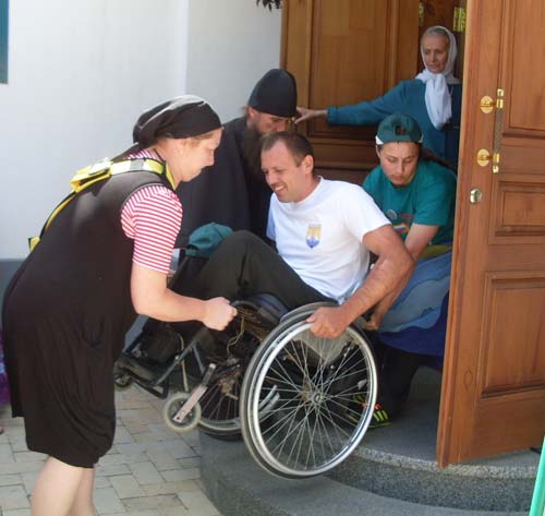 Пока отец Савва изучает нормативные документы по доступности, простые служители Лавры таскают коляски с инвалидами на себе