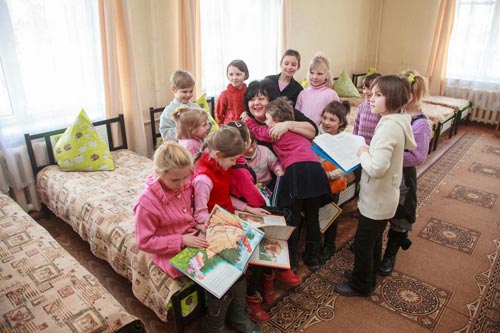 Представитель ЭМСС Нина Носенко читает ребятам книги,  подаренные Михаилом Гончаренко